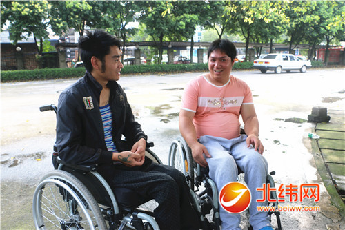 在驾校训练场上,2位双下肢截瘫残疾人相互交流学车感受