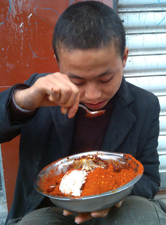 小夥在街頭吃辣椒麵拌飯(圖據網絡)